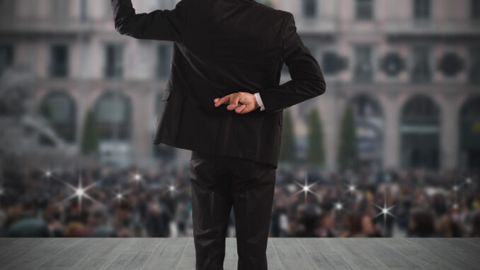 Man makes gesture with hand behind back