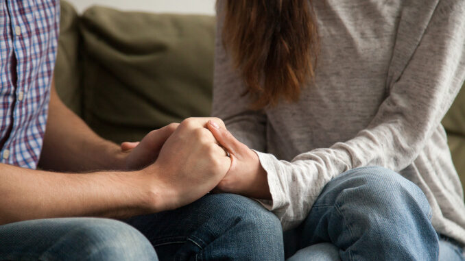 Close up of couple holding hands, support and understanding conc